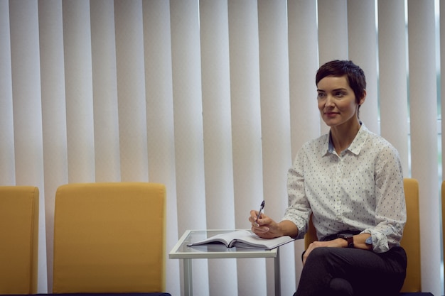 businesswoman-writing-diary-office_107420-96194